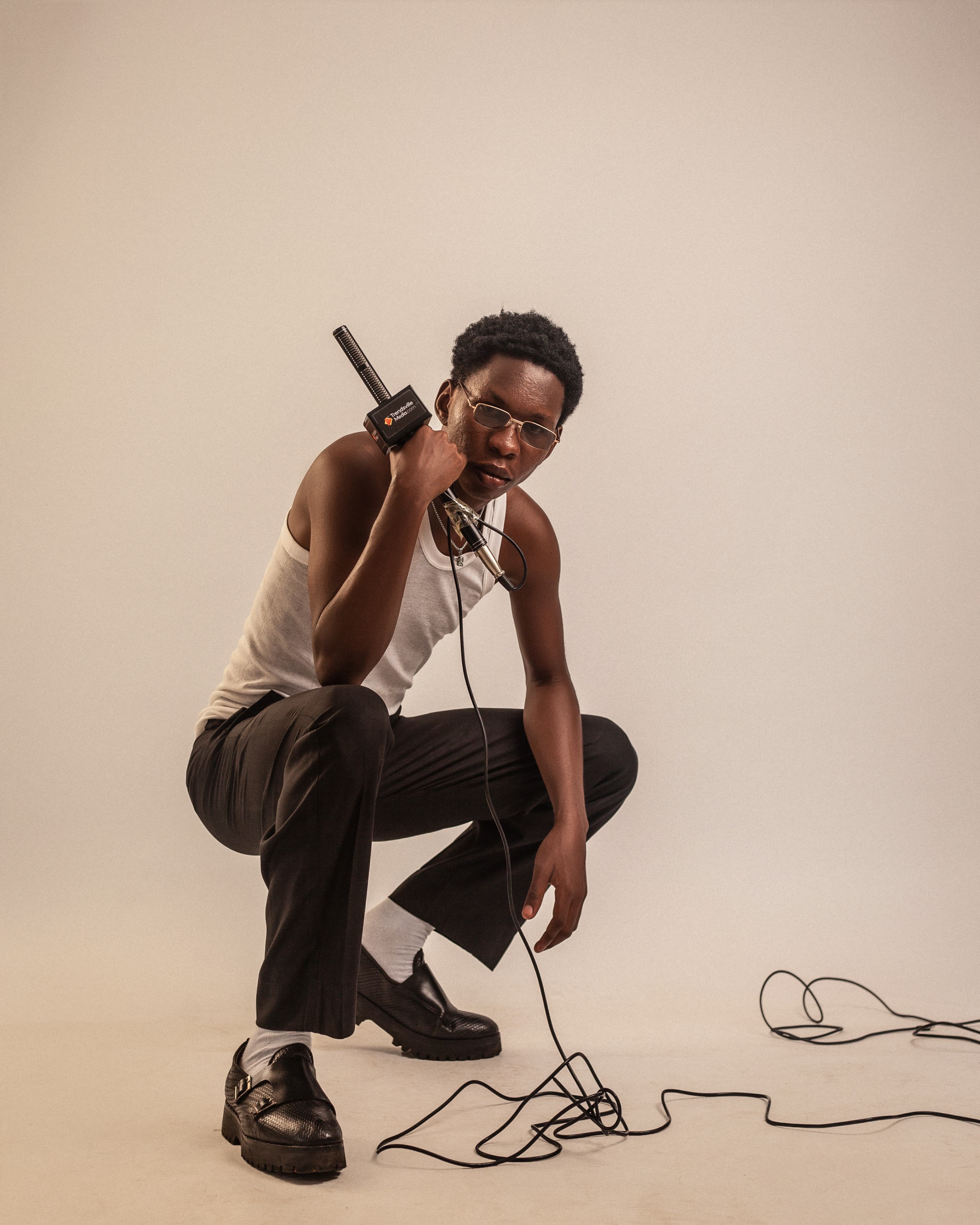 Muyii crouching with a microphone